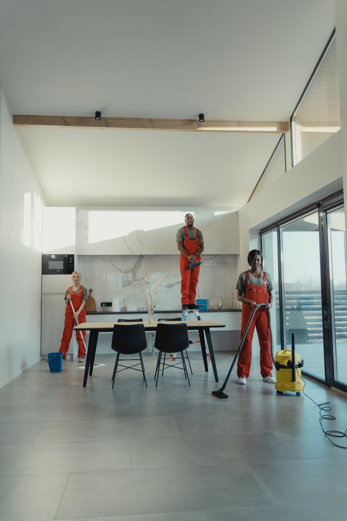 about-01 Team of professional cleaners working in a spacious, modern indoor setting.